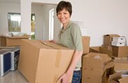 Smiling woman holding a moving box