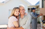 Smiling couple with a moving truck in the background